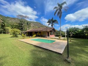 a house with a swimming pool and a palm tree at Cozy Farmhouse with Pool in Bom Jardim in Bom Jardim