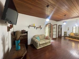 a living room with a couch and a flat screen tv at Cozy Farmhouse with Pool in Bom Jardim in Bom Jardim