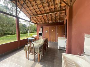 a dining room with a table and chairs and a large window at Cozy Farmhouse with Pool in Bom Jardim in Bom Jardim