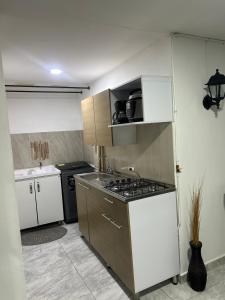 a small kitchen with a stove and a sink at Apartamento amoblado Chinchina in Chinchiná +2 photos