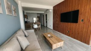 a living room with a couch and a flat screen tv at Grandeza by Palms Boca del Río in Boca del Río +8 photos