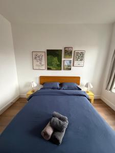 a bedroom with a blue bed with two stuffed animals on it at The Revival Guest House near Times Square in New York +12 photos