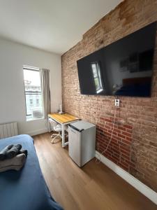 a bedroom with a brick wall with a desk and a bed at The Revival Guest House near Times Square in New York