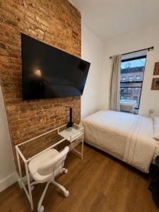 a bedroom with a bed and a brick wall at The Revival Guest House near Times Square in New York
