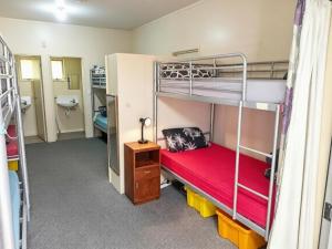 a room with two bunk beds and a bathroom at Eco Lodge Pakowhai in Hastings