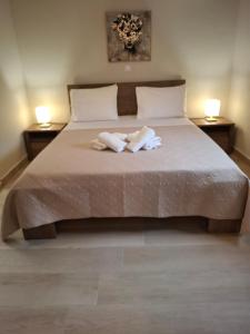 a bedroom with a bed with two towels on it at Stones villa corfu in Varypatádes +19 photos