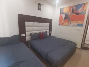 a bedroom with two beds and a painting on the wall at Tira Hotel and Cafe in Rudraprayāg