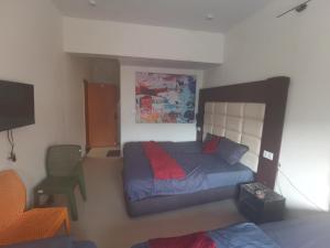 a bedroom with a bed and a chair at Tira Hotel and Cafe in Rudraprayāg