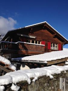 Cabaña de madera con nieve en el techo en Tgea sulagliva, en Andeer