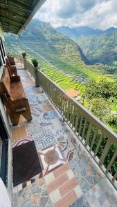 a balcony with a bench and a view of a valley at Batad Pension Ph in Banaue