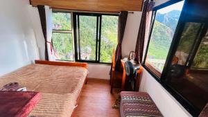 a room with two beds and large windows in a train at Batad Pension Ph in Banaue