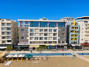 a large building with tables and chairs in front of it at Luxury sea view duplex in Durrës
