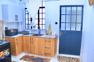 a kitchen with a blue door and a sink at Polea Hapa Ruaka in Nairobi
