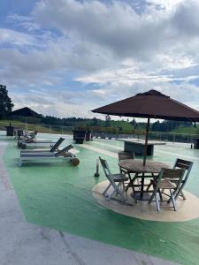 a table and chairs with an umbrella on a field at Hotel Rioverde Loft cerca De Aeropuerto Jmc in Rionegro