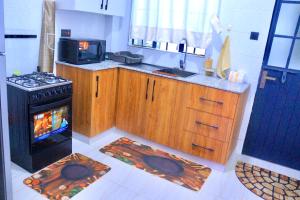 a kitchen with a stove and a microwave at Polea Hapa Ruaka in Nairobi