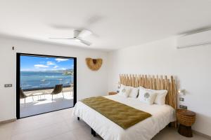 a bedroom with a bed and a view of the ocean at Résidence AMARILLO Vue mer exceptionnelle face à Saint-Barthélémy in Cul de Sac