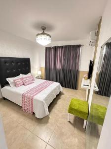 a bedroom with a bed and a table and a chair at Franco Residence in Santiago de los Caballeros