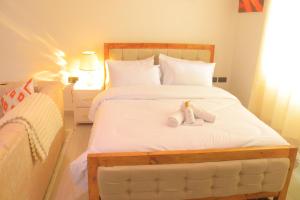a bedroom with a bed with two stuffed animals on it at Polea Hapa Ruaka in Nairobi