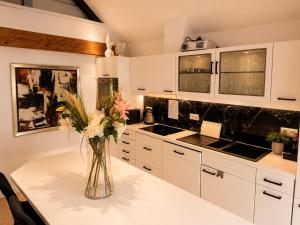 a kitchen with a vase of flowers on a table at Penthouse city & cathedral View for 4 in Antwerp