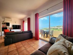 a living room with a couch and a large window at Vila Apostol in Lagos