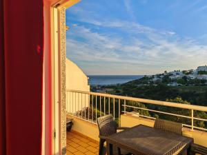 a balcony with a table and chairs and the ocean at Vila Apostol in Lagos