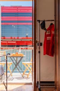 a balcony with a table and a red shirt on a door at Maranello Suite in Maranello
