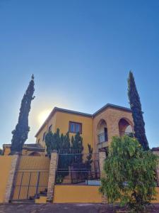 a house with a fence and two trees at Hospedaria 33 in Barretos