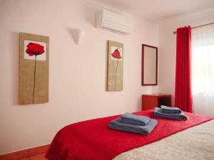 a bedroom with a red bed with towels on it at Vila Apostol in Lagos +80 photos