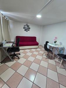 a living room with a red couch and two tables at Rincon Hortensia apartments and loft in Oaxaca City