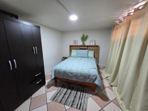 a small bedroom with a bed and a cabinet at Rincon Hortensia apartments and loft in Oaxaca City
