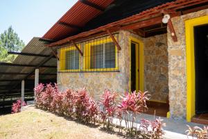 a house with a bunch of flowers in front of it at Hotel Posada La Ermita Cobán in Cobán