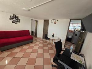 a living room with a red couch and a table at Rincon Hortensia apartments and loft in Oaxaca City