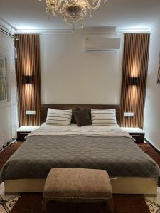 a bedroom with a large bed and a chandelier at APARTMENT AYOUB -for families only- in Nador