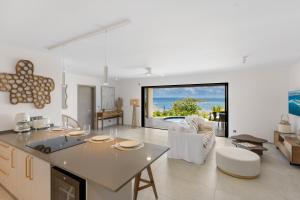 a kitchen and living room with a view of the ocean at Résidence AMARILLO Vue mer exceptionnelle face à Saint-Barthélémy in Cul de Sac