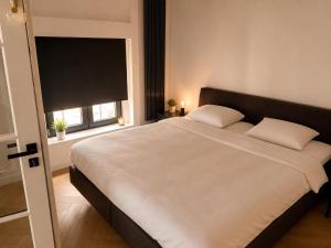 a bedroom with a large white bed with a window at Penthouse city & cathedral View for 4 in Antwerp