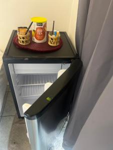 a small refrigerator with a shelf with food on it at rent room papeete in Papeete