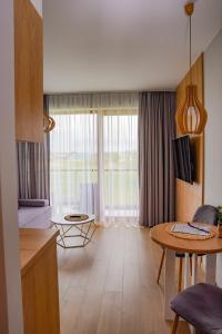 a living room with a table and a dining room at Przystań Apartamenty Sarbinowo in Sarbinowo