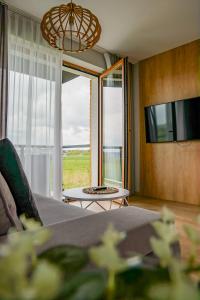 a bedroom with a bed and a large window at Przystań Apartamenty Sarbinowo in Sarbinowo