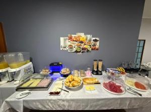 a table topped with plates of food and desserts at Cravinhos Park Hotel in Cravinhos