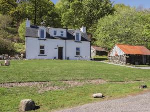 a white house on a hill with a yard at Tigh a Phailean in Letterfearn