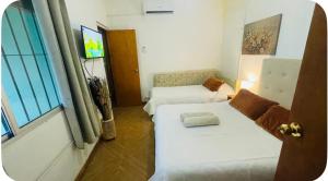 a small room with two beds and a window at Apto en Minas con amplio fondo, aire acondicionado, ideal para descansar in Minas