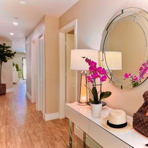 a room with a table with a mirror and flowers at Acqua Atelier by Vanderbilt Beach in Naples