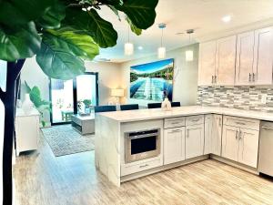 a large kitchen with white cabinets and a fireplace at Acqua Atelier by Vanderbilt Beach in Naples