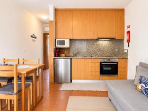 a kitchen and living room with a table and a couch at Gerês Trail House in Geres