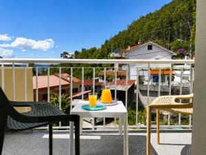 a balcony with two chairs and a table with two drinks on it at Gerês Trail House in Geres