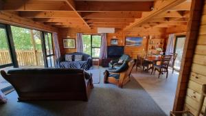a living room with couches and a dining room at 19 Torquay Terrace in Hanmer Springs