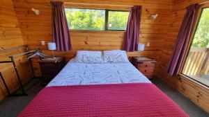 a bedroom with a bed in a log cabin at 19 Torquay Terrace in Hanmer Springs
