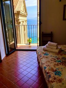 a bedroom with a view of the ocean from a balcony at La Locandiera affittacamere in Scilla