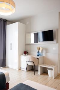 a white bedroom with a desk and a bed at Hotel Rossovino Como in Como