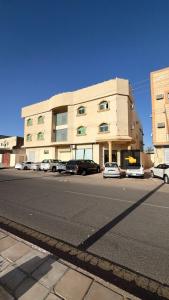 a building with cars parked on the side of a street at شقة مروج هاوس دخول ذاتي in Hail